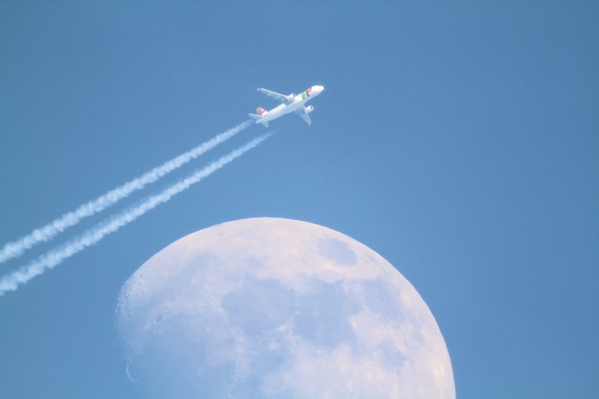 Ein Passagierflugzeug fliegt am Mond vorbei. Aufgenommen am 5.3.2012, bei Murrhardt.