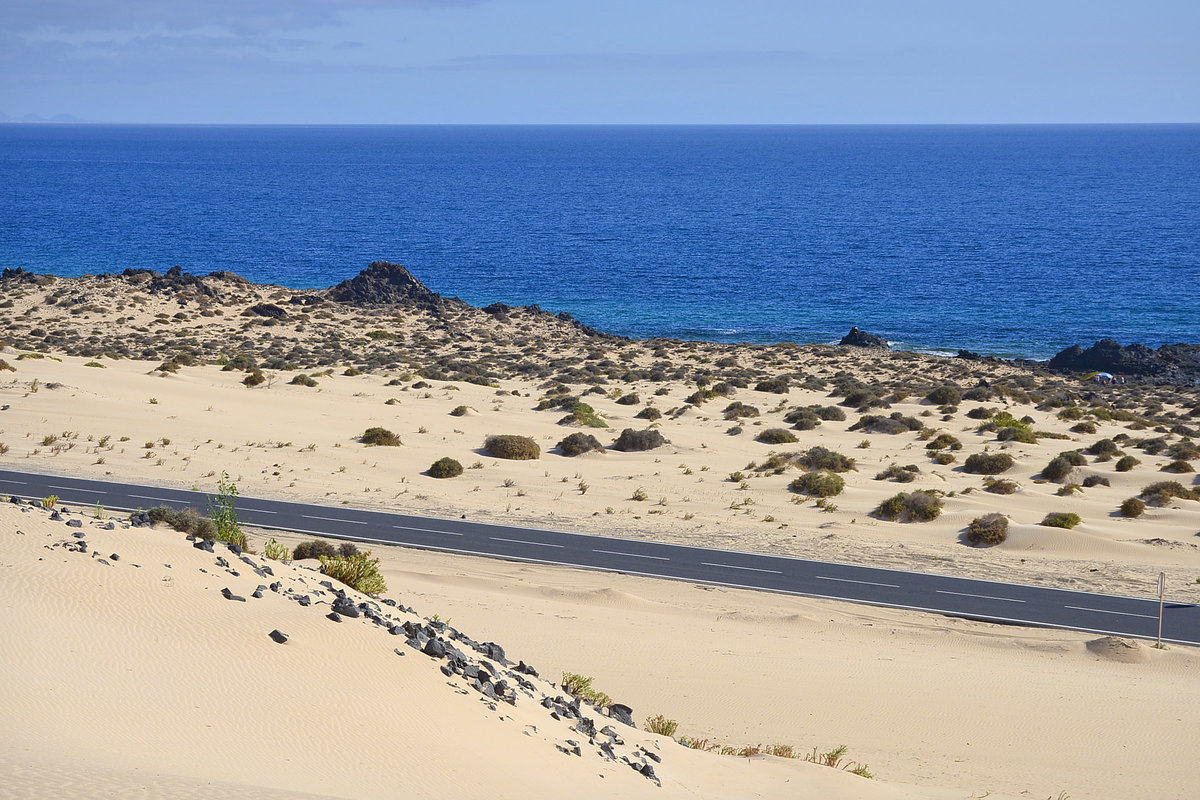 Fuerteventura in Spanien - Eine Strasse wurde mitten durch die Wanderdünen von Corralejo gebaut, die von Puerto del Rosario an der Ostküste Fuerteventuras entlang bis nach Corralejo führt.

Aufnahme: 18. Oktober 2017.