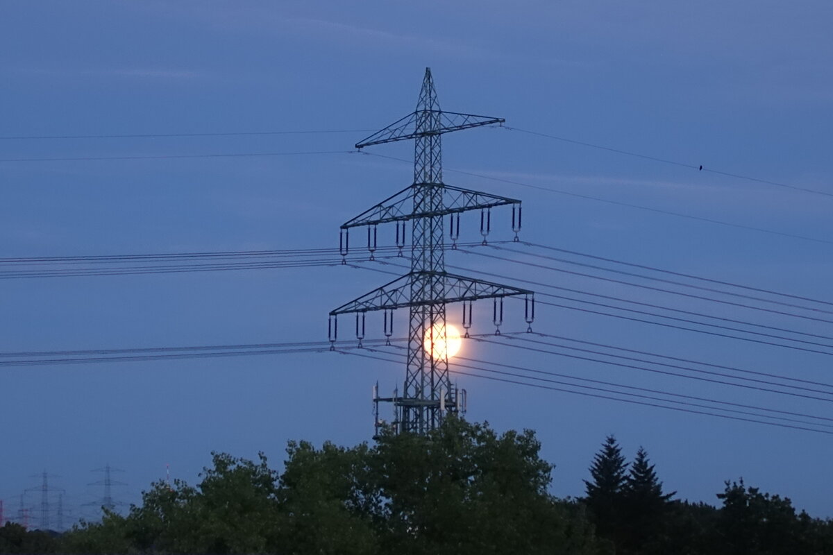 Hamburg am 12.7.2022: Mondaufgang (22:11 Uhr) über dem Osten der Stadt, noch versteckt hinter einem Strommast der europäischen Ringleitung/