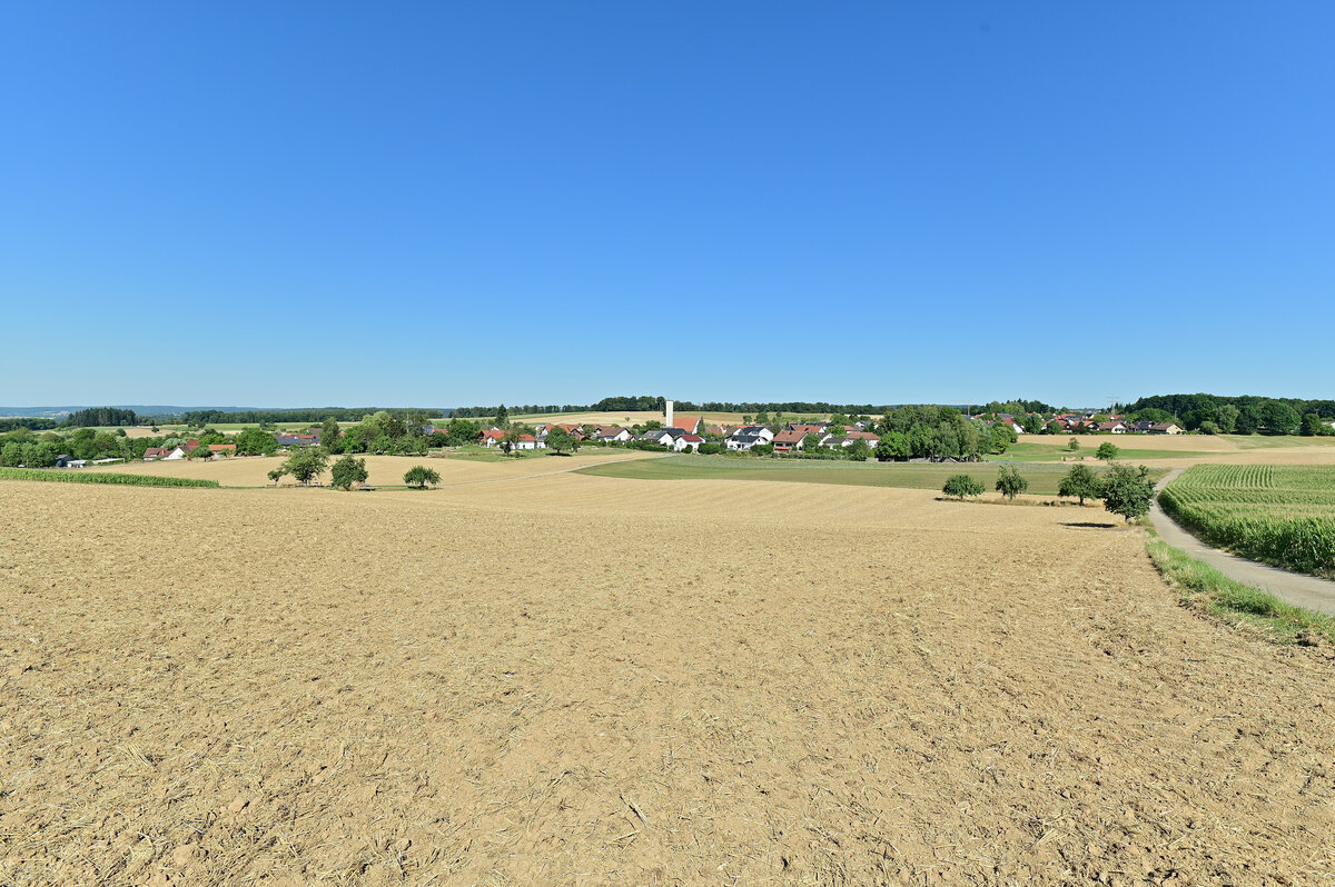 Im August sind mittelerweile die Getreidefelder abgeerntet, so auch am Hungerberg in Reichenbuch im Odenwald. In der Bildmitte ist die kath. Kirche von Reichenbuch zuerkennen, die neben der ev. Kirche eines der beiden signifikanten Bauwerke des Ortsteils von Mosbach darstellen. Im einschnitt des Waldrandes rechts sind noch einige Gebäude der Gemeinde Waldbrunn zu erkennen und dahinter der Katzenbuckel, der die höchste Erhebung des Odenwaldes ist. 9.8.2022