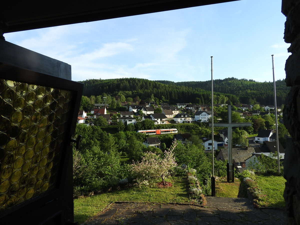 IM HELLERTAL ZWISCHEN WESTERWALD UND SIEGERLAND

Aus dem Innenraum der FATIMA-Kapelle im HERDORFER Vorort SASSENROTH fällt am
8.6.2016 der Blick auf den Ort mit dem Triebwagen der

HELLERTALBAHN auf seiner Fahrt von BETZDORF/SIEG nach NEUNKIRCHEN/SIEGERLAND
und dem Förderturm des BERGBAUMUSEUMS.....