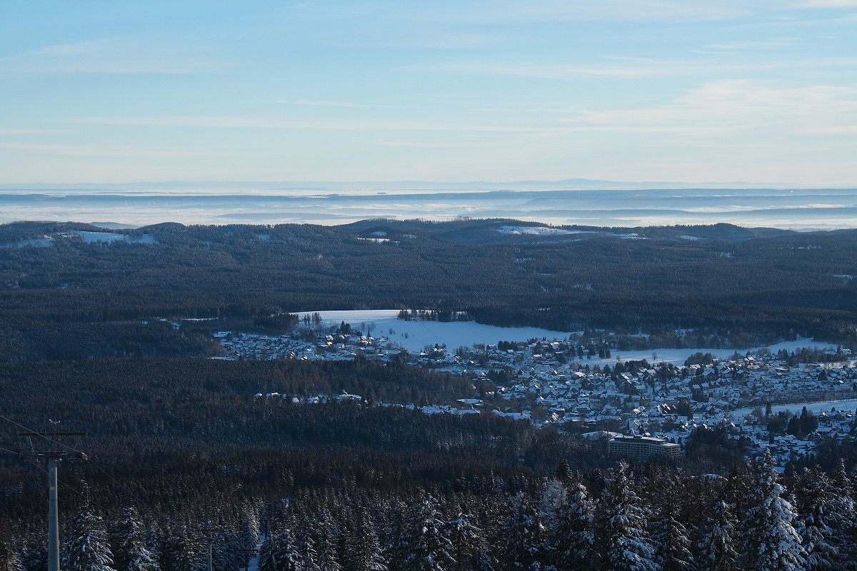 In der Ferne das gesamte Mittelgebirge Thüringer Wald am Horizont und vorne im Tal vor der Kulisse des Südharzes  Braunlage; etwas rechts von der Mitte am Horizont die markante Form des Großen Inselsbergs, über 100 km entfernt; So, 14.02.2021 am frühen Abend...