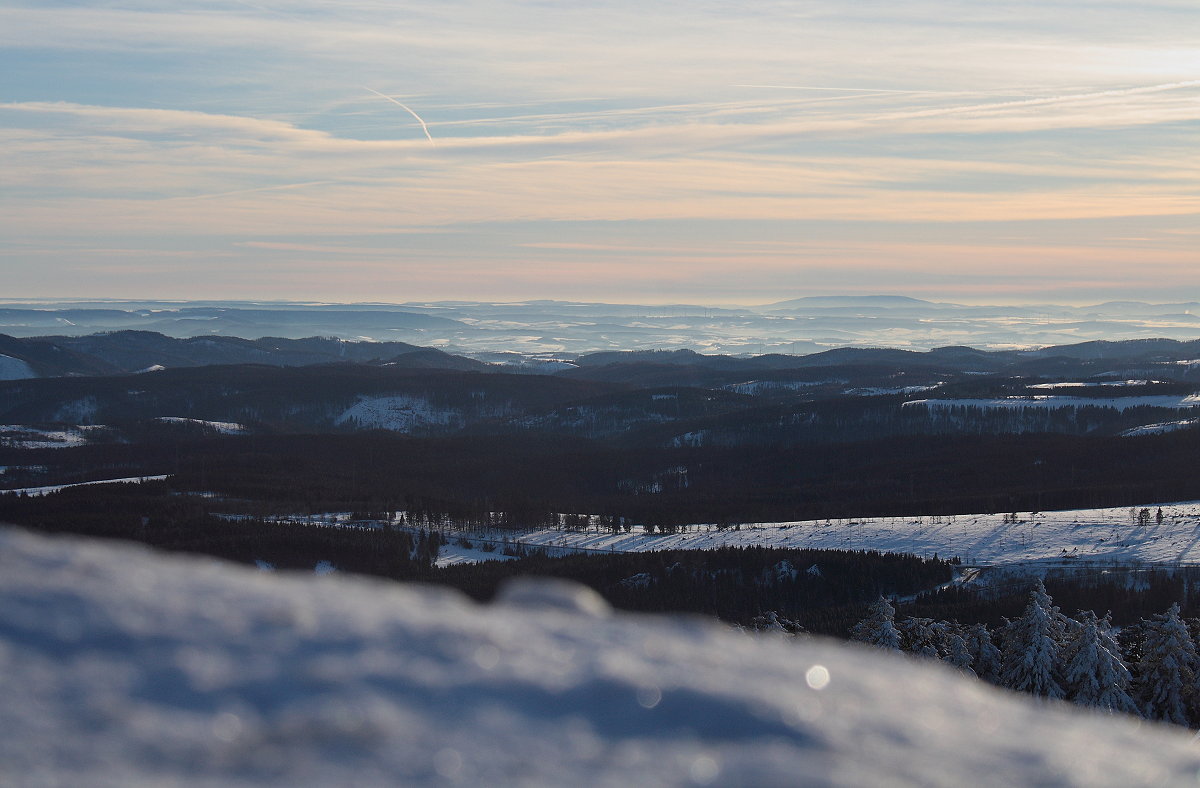 In der Ferne sieht man vom Wurmberg bis in die Kasseler Gegend, hier etwas rechts von der Mitte am Horizont der breite Rücken des Basalttafelbergs Hoher Meißner in Hessen, ca. 80 km entfernt; So., 14.02.2021 am späten Nachmittag...