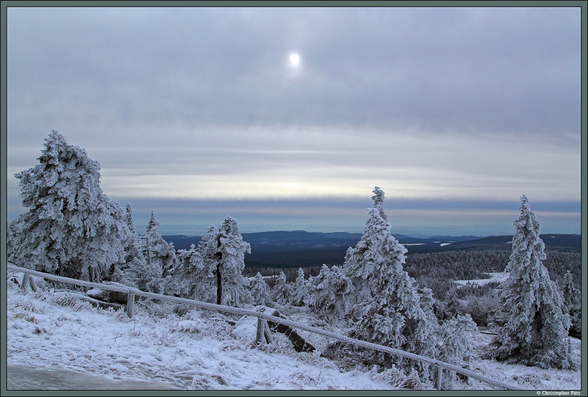 In den letzten Dezembertagen hat der Winter auf dem Brocken Einzug erhalten. Durch den kräftigen Wind erreichen die Bäume hier nur geringe Höhen, der Gipfel liegt bereits oberhalb der Baumgrenze. Im Hintergrund schweift der Blick über den Hochharz hinz zum südlichen Rand des Harzes. (27.12.2014) 