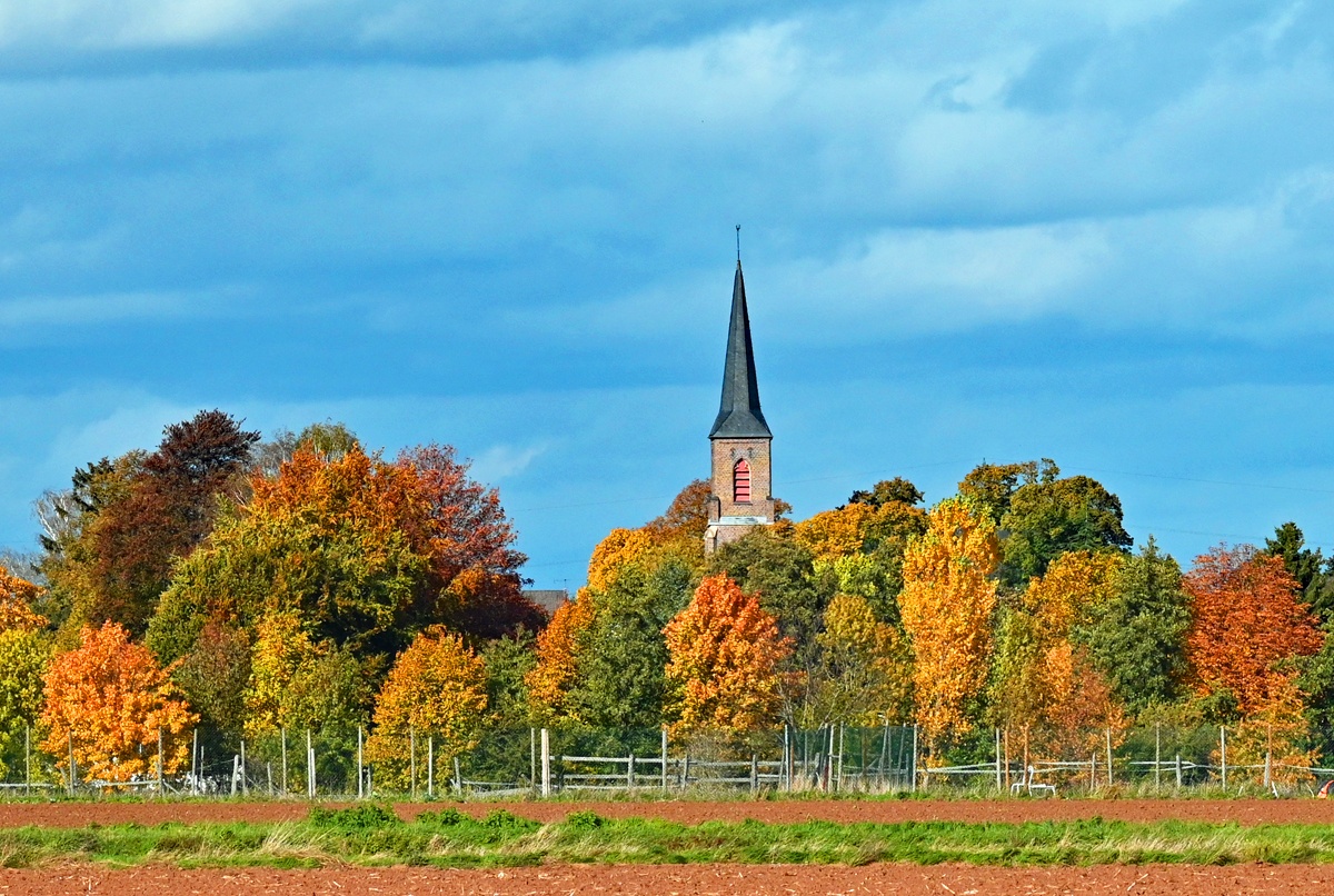 Kirche hinter herbstlich gefärbten Bäumen in Eu-Euenheim - 22.10.2020