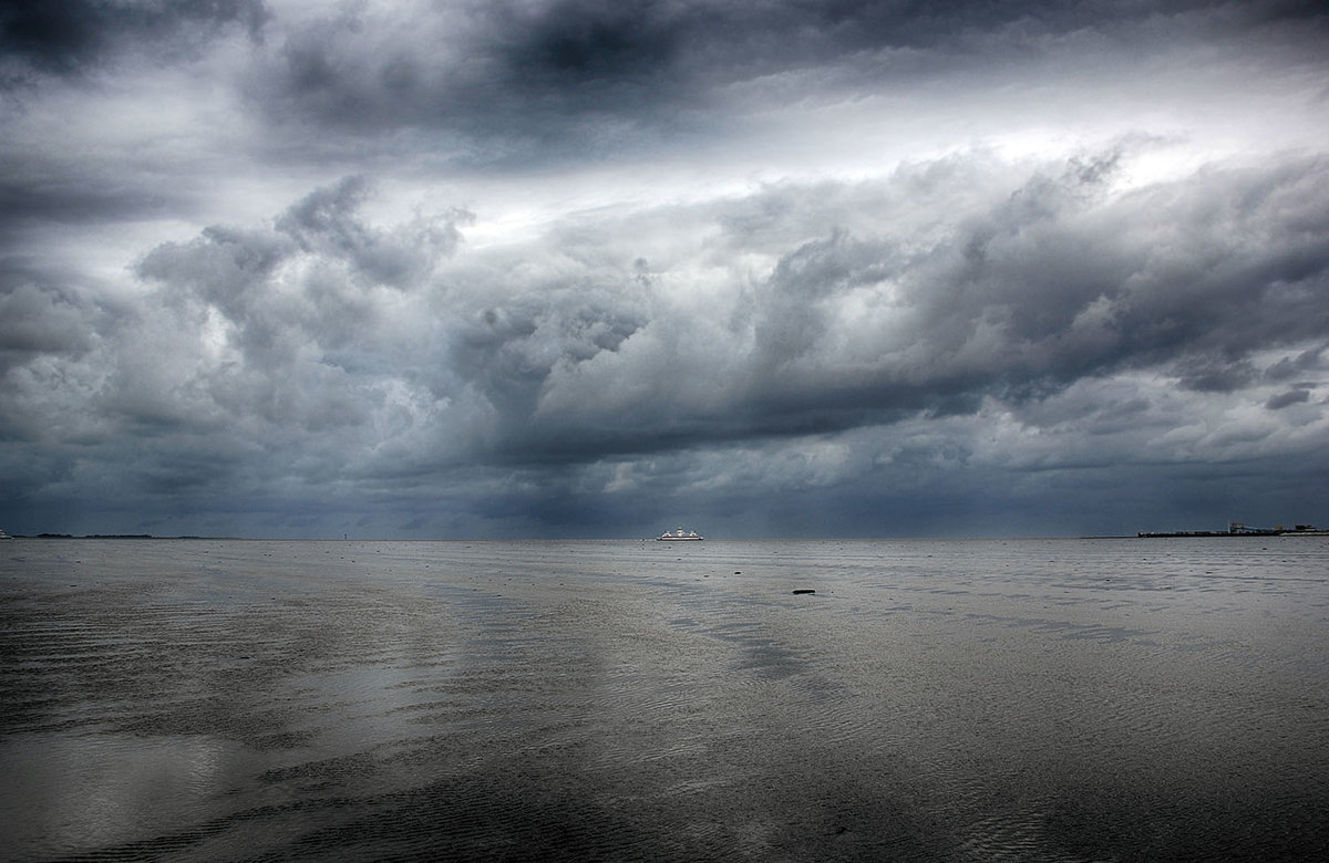 Regenwolken über das Nordfriesische Wattenmeer zwischen der Insel Föhr und der Hallig Oland. Das Foto ist während einer Wattwanderung aufgenommen. Aufnahme: 25. Juni 2017.