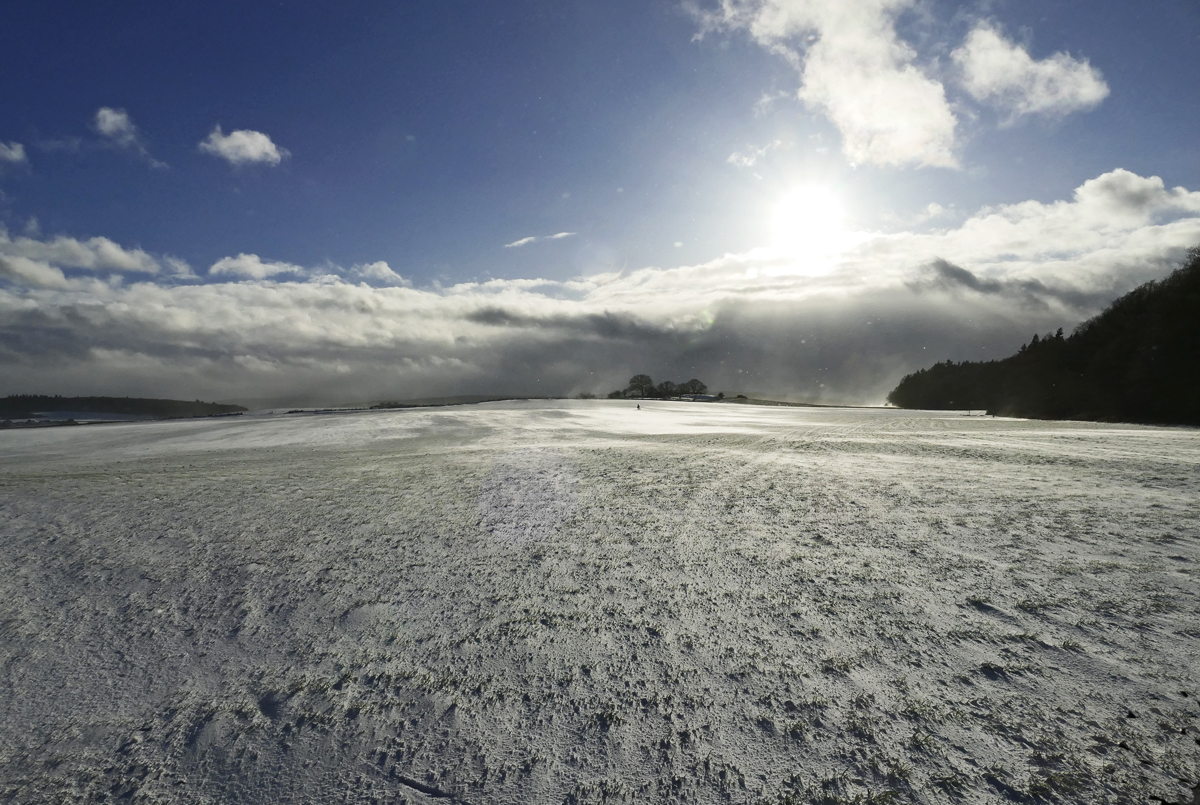 Schnee, Sturm, Sonne, Wolken und ein  Pünktchen Mensch  auf der hell beschienenen Schneefläche in Bildmitte, Eifel 10.12.2017