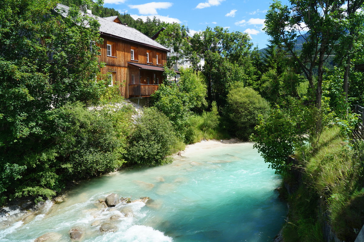 Sommeridylle an der Isar: Unweit ihres Ursprungs im Karwendelgebirge ist die Isar noch ein kleiner Gebirgsfluss. Im Zentrum des auf fast 1000 m gelegenen Ortes Scharnitz an der österreichisch-deutschen Grenze bot sich am hochsommerlich heißen 05.07.2020 dieser Blick auf die türkisfarbene Isar, die sich ihren Weg durch den Ort in Richtung München bahnt.