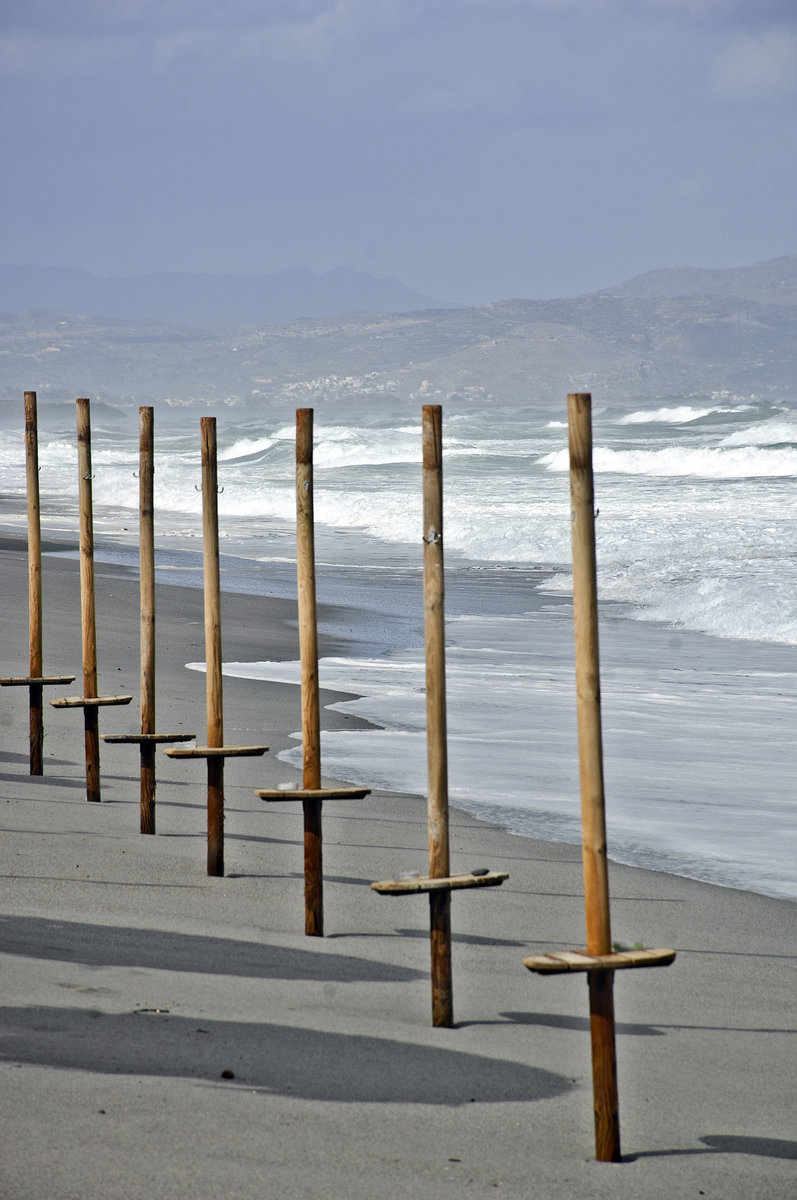 Sonnenschirm-Pfosten am Strand vor Geranie auf Kreta. Aufnahme: 18. Oktober 2016.