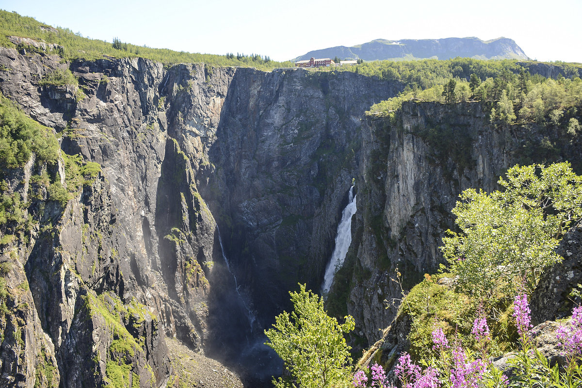 Vøringsfossen von der Hauptstraße Rv7 aus gesehen. Der Wasserfall liegt am Westrand der Hardangervidda in Eidfjord. Der kleine Fluss Bjoreio, in dessen Verlauf der Vøringsfossen liegt, wird oberhalb des Wasserfalls im Tal Sysendalen durch den Sysendamm gestaut und für die Stromproduktion verwendet. Die Wassermenge ist daher eingeschränkt, wird allerdings aus touristischen Gründen im Sommer vom 1. Juni bis 15. September auf zirka 12 m³ Wasser pro Sekunde erhöht, was etwa der natürlichen Durchflussmenge entspricht
Aufnahme: 7. Juli 2018.