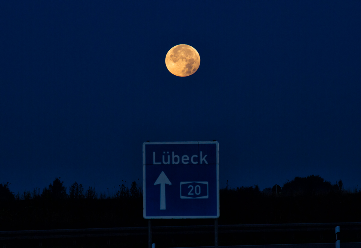 Vollmond über dem Richtungsschild an der A 20. - 28.09.2015