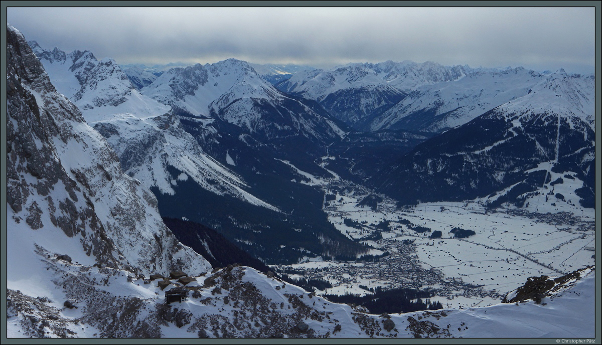 Von der Westflanke der Zugspitze aus ist der Ort Ehrwald zu sehen. Von links nach rechts erheben sich die Berge Sonnenspitze (2417 m), Wannig (2493 m) und Grubigstein (2233 m). (bei Ehrwald, 03.03.2018)