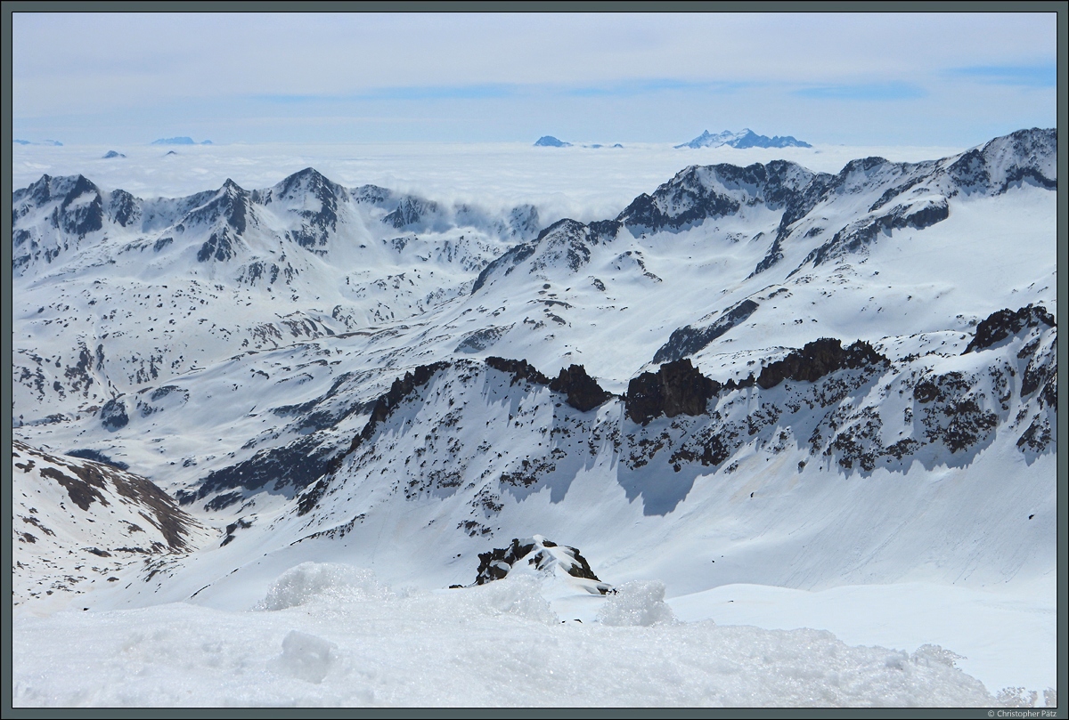 Wolken schwappen über die Berggipfel der Alpen bei Andermatt. (Gemsstock, 21.04.2022)