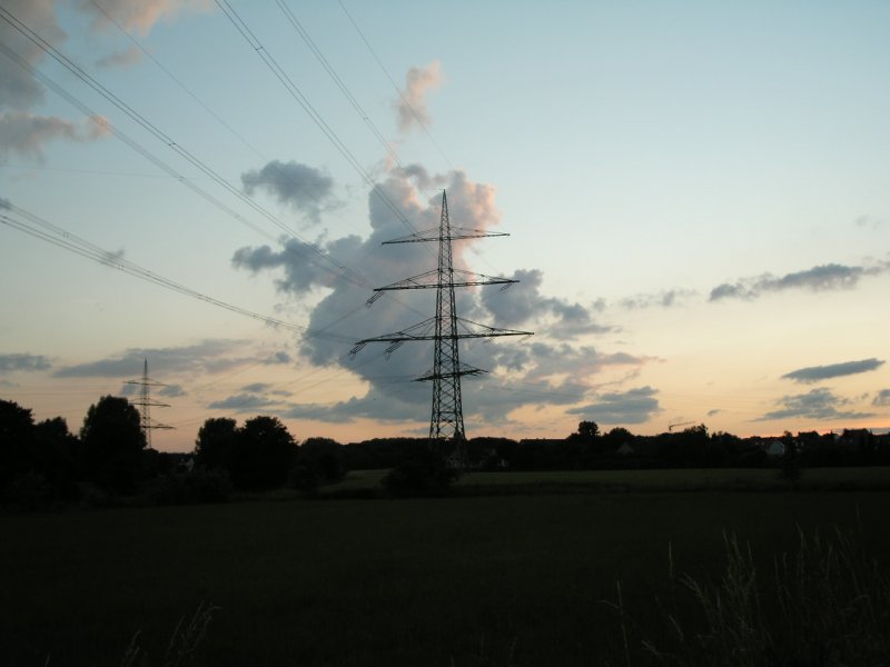 Abendhimmel mit Wolken und Hochspannungsmast im Mnsterland am 19.06.2004.