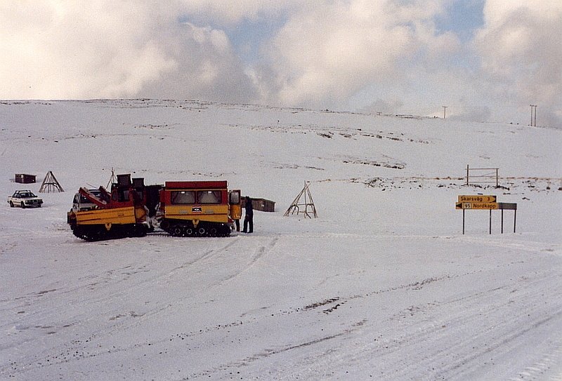 Abzweigung der Nordkapp-Strae vor Skarsvag auf der Insel Mageroya, hier warten zwei Kettenfahrzeuge mit Kettenanhngern auf einen Bus, um Touristen auf der nicht gerumten Strae zum Nordkapp zu bringen, Mrz 1992.