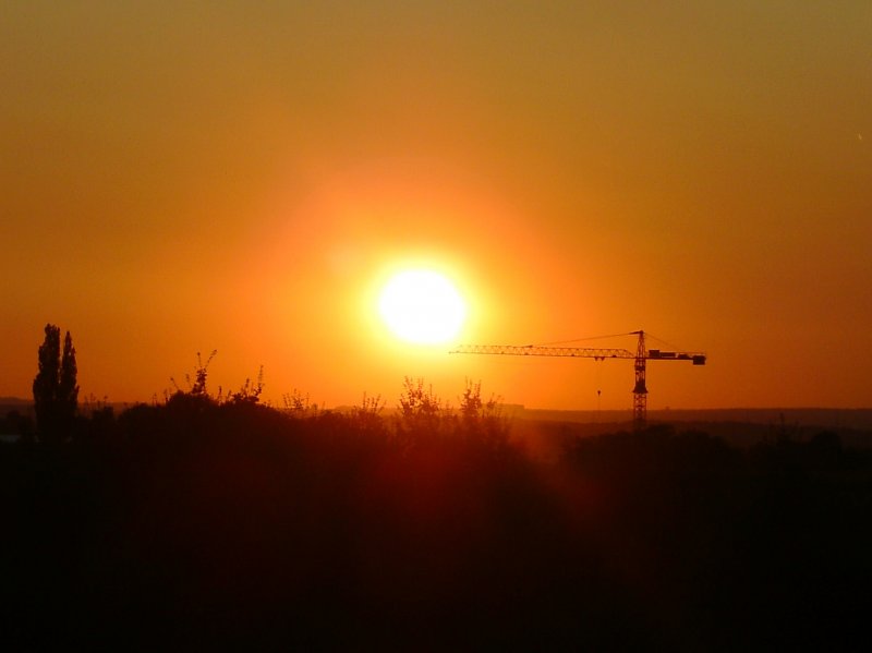 Der Baukran steht im richtigen Winkel und der Sonnenuntergang beendet den heien 25.7.2008. Aufgenommen bei Bissingen an der Teck.