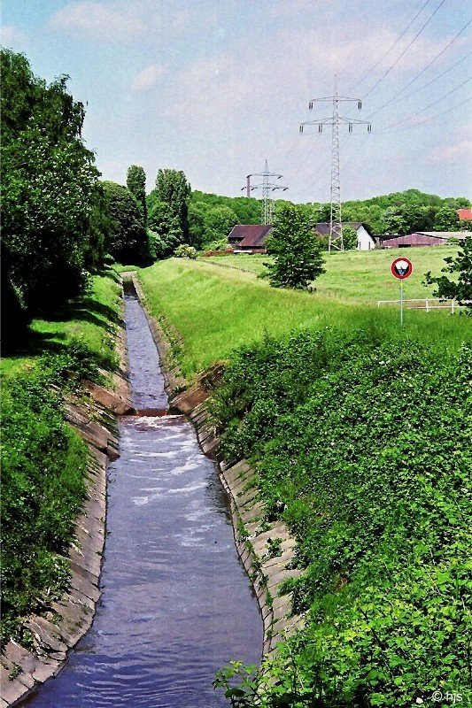 Der Hller Bach in Bochum-Hordel (18. Mai 2007). Typisches Erscheinungsbild der Bche in der Emscher-Region: als in Folge von Bergsenkungen in manchen Gebieten der Abfluss des Wassers nicht mehr gewhrleistet war, griff zu Beginn des vorigen Jahrhunderts die Emschergenossenschaft ein und lie die Emscher und ihre Nebenbche kanalisieren. Die Bche wurden begradigt, in Betonrinnen verlegt und eingedeicht. 