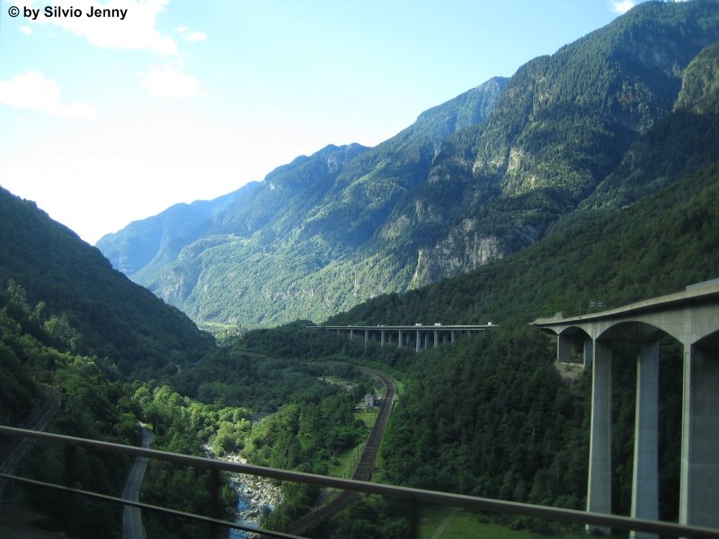 Die Biascina Schlucht vom Zug heraus fotografiert am 3.8.07. Rechts im Bild die grosse Autobahnbrcke. Links die 2. Etage der Biascina-Kehrschlaufe der Gotthardbahn und die Kantonsstrasse. In der Mitte fliesst der Ticino sdwrts, whrend im die unterste Etage der Gotthardbahn parallel folgt.