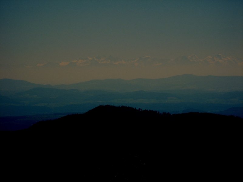 Diese Fernsicht von ber 100 Kilometern hatte man am 01.08.2007 vom Blauen (Hochblauen), 1165 m, im Sdschwarzwald. Zu sehen waren ber dem Dunst im schweizer Mittelland natrlich die 3- und 4000er der Alpen, davor der Jura (Basel-Land bzw. Aargau) und davor der Dinkelberg bzw. Oetlinger Hgel bei Lrrach. Das Bild ist etwas dunkler dargestellt, zwecks der  Highlights .