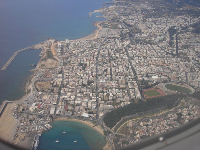 Ein Blick aus dem Fenster des Fliegers beim Landeanflug auf die Insel Rhodos. Die Maschinen fliegen in einem weiten rechtsbogen ber das Meer um ber die Altstadt von Rhodos zu gleiten und dann auf dem Flughafen in Paradissio zu landen. Diesen Anblick kann man aus der Altstadt sehr gut geniessen weil die Flieger dort schon in geringer Hhe mit ausgefahrendem Fahrwerk zu sehen sind.