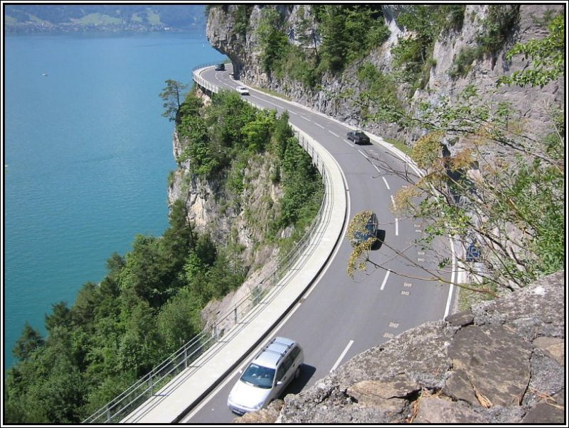 Eine Strae (zwischen Interlaken und Thun) schmiegt sich in die Felsen oberhalb des nrdlichen Ufers des Thuner Sees. (Juli 2003)
