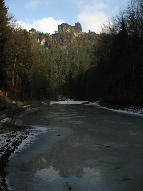 Genau dort, wo sich der Sandsteinfelsen  Lokomotive  spiegelt, hat das dünne Eis den Amselsee offen gelassen; im Amselgrund bei Kurort Rathen (Sächsiche Schweiz), 15.01.2008
