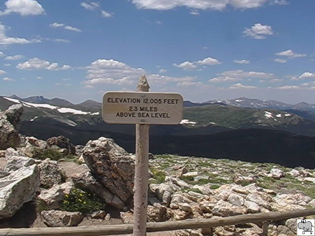 Im Nordwesten des US-Bundesstaates Colorado befindet sich der Rocky Mountain Nationalpark.Im Jahre 1859 kam Joel Estes und sein Sohn Milton erstmals in die Gegend (in ein groes Tal) 2o Meilen nrdlich von Lyons. Ein Jahr spter kamen sie wieder mit Ihren Familien in die Region und begannen eine Siedlung aufzubauen. Um 1909 pldierten meherere Umweltschtzer, dieses Gebiet zu einen Nationalpark zu machen, welches im Jahre 1915 vollzogen wurde, als zehnter Nationalpark der USA. Ein Hauptgrund hierfr ist, das eindrittel des Parkes oberhalb der Baumgrenze (Tundra) liegt. Ein Stck oberhalb des Alpine Visitor Center befindet sich dieses Schild, welches eine Erhebung von 12005 Feet (3658 Meter) ausweist. Bei unseren Halt am Alpine Visitor Center am 15. Juli 2006 liesen wir es uns nicht nehmen, den kleinen Wanderweg zum Gipfel zurckzulegen. Den hchsten Punkt an diesen Tag erreichten wir aber kurz hinter dem Alpine Visitor Center, als wir mit den Bus ber 12183 Feet (3718 Meter) fuhren.