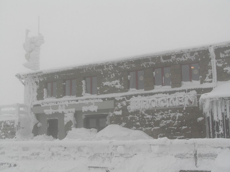 Sieht sehr kalt aus. War es auch. -7 um 12 Uhr. Zu sehen, jedenfalls bei der Klte noch knapp zu erkennen, der Brockenbahnhof der Harzer Schmalspurbahn auf dem Brocken mit einer Hhe von 1.125 Metern. Die Brockenkuppe selbst hat 1.142 Meter. Das Schild  Brocken  ist auch vom Schnee eingefroren. Sieht irgendwie beeindruckend aus :) War aber sehr kalt. Links oben kann man gerade noch den Sendemast tief vereist sehen. Der eisige Tag war der 30.11.2005