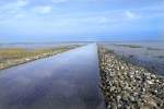 Der Wattweg bei Mandø im dänischen Wattenmeer. Erreichen kann man Mandø mit dem Auto über den Låningsvej, eine Art Damm, der bei normalem Hochwasser nicht passierbar ist, da er nur aus flach aufgeschütteten Schotter besteht und durch Buhnen befestigt ist. Neben den Gezeiten richtet sich die Passierbarkeit auch nach dem herrschenden Wind - bei starkem westlichem Wind ist der Zeitraum um das Niedrigwasser, in dem der Låningsvej passierbar ist, deutlich kürzer. Aufnahme: 2. September 2006.