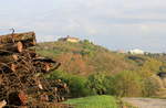 Stadtsilhouette von Waldenburg über der Kulisse von Holzstapel, Acker und Feldweg am 17.04.2020.