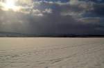 Aus Richtung Sinsheim ziehen dunkle Schneewolken gen Reichenbuch,  die Sonne kämpft sich noch durch die anrückende Wolkenwand.