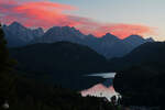 Ein rot gefärbter Abendhimmel über den Alpsee.