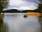 Hinter der Canower Schleuse erstreckt sich der Canower See, den gerade ein Kanu in östlicher Richtung befährt.