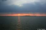 Zur Abwechslung mal ein Sonnenaufgang: Der Feuerball erhebt sich langsam ber der Insel Rgen und zieht eine schillernde Bahn im Strelasund. Aufgenommen am Morgen des 21. August 2009 im Stralsunder Freibad.

