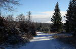 Blick über die winterliche Landschaft um die Hahnenkleer Waldstraße unter Schnee bis zu Bergreihen des Südharzes am Horizont; später Nachmittag des 21.11.2022...