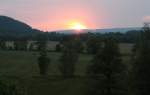 Sonnenuntergang über dem Tal von Nunkirchen/Saar; die Sonne versinkt im Hintergrund hinter den westlichen Bergen des Hunsrück; Aufnahme vom Abend des 09.06.2013... 
