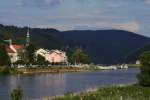 Blick ber die Stadt Bad Schandau ins Elbtal, stromaufwrts in die Schsische Schweiz/Tschechische Grenze. Unterhalb der im Hintergrund zu sehenden Berge befinden sich die bekannten  Schrammsteine . An der Anlegestelle  Bad Schandau  ist gerade der Elbdampfer  Kurort Rathen  zu sehen. Diese Zoom-Aufnahme entstand am 23.06.2012 vom Bahnhof Bad Schandau aus.