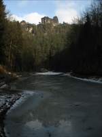 Genau dort, wo sich der Sandsteinfelsen  Lokomotive  spiegelt, hat das dnne Eis den Amselsee offen gelassen; im Amselgrund bei Kurort Rathen (Schsiche Schweiz), 15.01.2008
