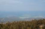 Brockenlandschaft aus Sonne und Wolken: Die Berge des nordstlichen Harzes, Darlingerode und ein Rapsfeld unter strahlendem Sonnenlicht, whrend das Harzvorland nrdlich davon noch unter dem dunklen