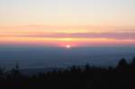 Sonnenaufgang auf dem Brocken: Die halbe Morgensonnenscheibe hat sich über die Erdoberfläche in der Ferne gehoben; Blick am frühen Morgen des 13.08.2012 vom Gipfelrundweg Richtung Osten über
