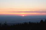 Sonnenaufgang auf dem Brocken: Die halbe Morgensonnenscheibe hat sich ber die Erdoberflche in der Ferne gehoben; Blick am frhen Morgen des 13.08.2012 vom Gipfelrundweg Richtung Osten ber Wernigerode und das nordstliche Harzvorland.