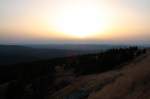 Sonnenuntergang auf dem Brocken; bald wird die Sonne hinter einer Wolkenwand in der Ferne versinken. Blick am Abend des 19.08.2012 vom Gipfelrundweg Richtung Westen ber Berge des Oberharzes bis zu den Weserberglandschaften am Horizont.