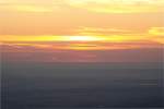Auf dem Brocken vor Sonnenaufgang: die Sonne zeigt sich als zartes Glühen am Horizont; Blick am frühen Morgen des 28.08.2012 von der Treppe des Brockenhauses über das nordöstliche Harzvorland