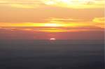 Sonnenaufgang auf dem Brocken: Stück für Stück hebt sich die Sonne über die Erdoberfläche; Blick am frühen Morgen des 28.08.2012 von der Treppe des Brockenhauses über das nordöstliche Harzvorland