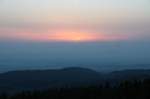 Die leuchtende Sonnenscheibe erscheint am Horizont in der Ferne; Blick am frhen Morgen des 19.06.2013 von der Treppe des Brockenmuseums auf dem Brockengipfelplateau...