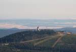 Der Gipfel des Wurmbergs mit dem ca. 30 m hohen Turm der Skisprungschanze, dahinter ber den letzten Gipfeln des Sdharzes die Hainleite in Thringen mit ihrem Wechsel von Feldern und Wald, darber bzw. dahinter zart am Horizont die hchsten Berge des Thringer Walds, ca. 120 - 130 km entfernt; Blick am frhen Abend des 21.07.2013 vom Gipfelrundweg des Brocken Richtung Sden...