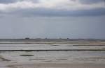 Lttmoorsiel - 14.06.2008 - Blick vom Deich zur Hallig Nordstrandischmoor mit den 4 Warften und im Hintergrund die Insel Pellworm. Im Watt erkennbar die Lebensader zur Hallig, der Damm der Lorenbahn und auf ihm eine Lore, unser Taxi.