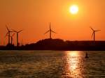 Abendstimmung mit den sich langsam drehenden Windrädern am Burger Binnensee auf Fehmarn.