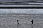 Das Wattenmeer bei Ebbe vom Deich bei Lüttmoorsiel aus gesehen. Im Vordergrund stehen Sie Wattwanderer auf dem weg nach Nordstranischmoor. Aufnahme: Mai 2008.