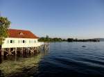 Abendstimmung am bayerischen Bodenseeufer. Das Badehaus von Lindau-Aeschach, der Bodenseedamm und die Insel Lindau am 17.08.2011.